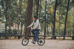 Happy Asian young woman walk and ride bicycle in park, street city her smiling using bike of transportation, ECO friendly, People lifestyle concept. photo