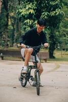 hermoso contento joven hombre con bicicleta en un ciudad calle, activo estilo de vida, personas concepto foto