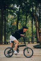 hermoso contento joven hombre con bicicleta en un ciudad calle, activo estilo de vida, personas concepto foto