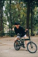 hermoso contento joven hombre con bicicleta en un ciudad calle, activo estilo de vida, personas concepto foto