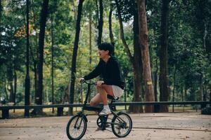 hermoso contento joven hombre con bicicleta en un ciudad calle, activo estilo de vida, personas concepto foto