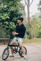 hermoso contento joven hombre con bicicleta en un ciudad calle, activo estilo de vida, personas concepto foto