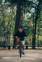 hermoso contento joven hombre con bicicleta en un ciudad calle, activo estilo de vida, personas concepto foto