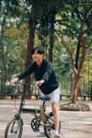 hermoso contento joven hombre con bicicleta en un ciudad calle, activo estilo de vida, personas concepto foto