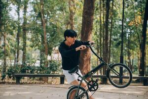 hermoso contento joven hombre con bicicleta en un ciudad calle, activo estilo de vida, personas concepto foto