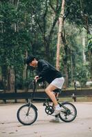 hermoso contento joven hombre con bicicleta en un ciudad calle, activo estilo de vida, personas concepto foto