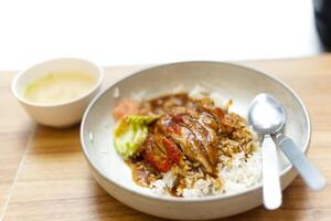 roasted duck over rice Serve with pickled ginger, cucumber and soup. with fork and spoon photo