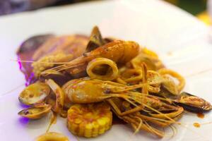 Mariscos Cubeta en blanco antecedentes servir con camarón, maíz, almejas, calamar foto