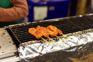 grilled chicken and pork on the stove cooker on thai street market food style photo