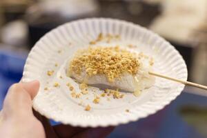 grill Mochi with skewers serve on paper plate in the night market photo