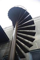 espiral escalera , escalera a el techo con antecedentes cielo foto