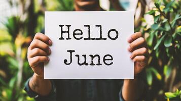 AI generated Hello June. Closeup of a woman holding a card with the word Hello June in her hands photo