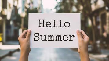 AI generated Closeup of hands holding paper with Hello Summer text on blurred background photo