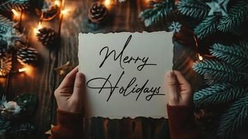 AI generated Merry Christmas lettering. Woman's hands holding a card with the text Merry Christmas. photo