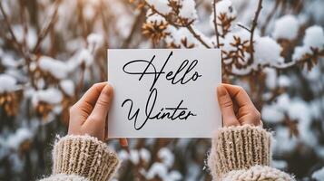 AI generated Female hands holding a card with Hello Winter text. Winter background. photo