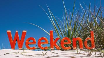 AI generated The word Weekend is written in red letters on the sand photo