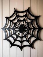 AI generated Black spider web hanging on white wooden wall. Halloween decoration concept. photo