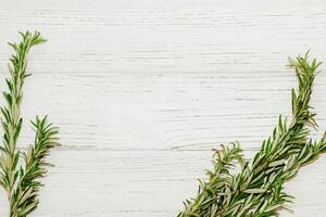 Sprigs of rosemary spices on a table with wooden boards, space for text. photo