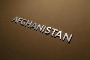 la palabra afganistán colocada con letras de metal plateado sobre tela de lona de color caqui marrón áspero foto