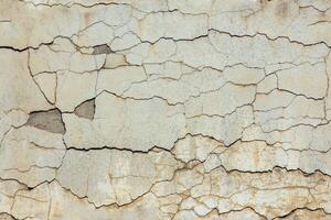 cracked white concrete wall under direct sun light full frame background and seamless texture photo