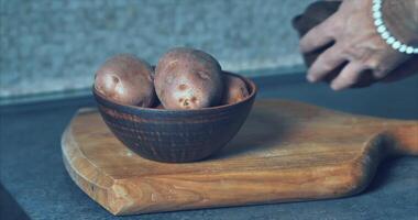 Kartoffeln im ein Lehm Teller und ein Lehm Topf zum Backen im das ofen-filmisch 4k video