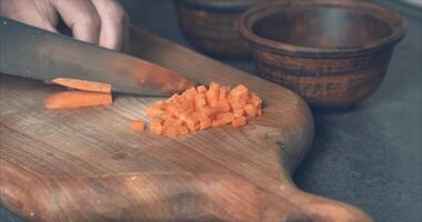 culinaire techniek voor snijdend groenten. wortels voor bakken in de oven met aardappelen. oven video