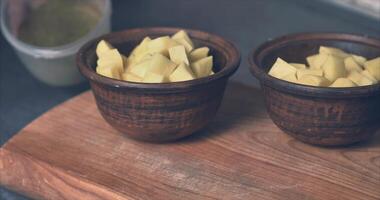 Cutting potatoes for baking in clay pots video