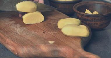 Cutting potatoes for baking in clay pots 4k video