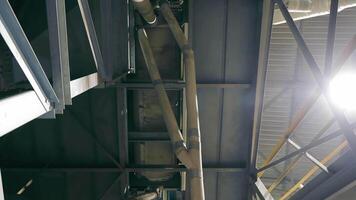 complexe plafond cadre dans industriel bâtiment, complexe métal poutres et tuyaux de un industriel plafond contre dans le milieu de le ascenseur. video