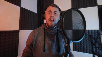 Musician Recording Vocals in Soundproof Studio, ale artist singing into microphone with pop filter in acoustically treated recording studio. video