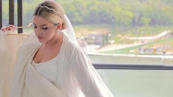 Braut einstellen Kleid durch Fenster. Braut einstellen ihr funkelnd Hochzeit Kleid durch das Fenster. video