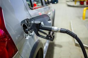 silver color car refueling on gas station - close-up photo