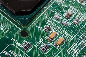 wet digital circuit board with microprocessors and components, closeup full-frame macro background photo