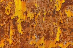 beautifully rusted thick sheet metal with leftovers of yellow paint texture and full-frame background photo