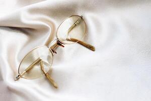 lentes en un oro marco con dioptrías en un seda antecedentes foto