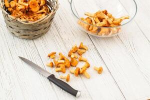 Cantharellus Cibarius, chanterelle mushrooms yellow on a board with a knife photo