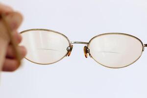 Glasses in a gold frame with diopters in hand photo