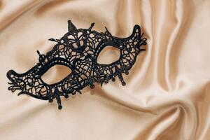 black stylish masquerade mask on golden silk photo