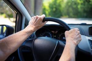 Car driving background. Steering wheel with driver's hands photo