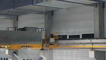 Large yellow overhead crane in industrial warehouse setting, no cargo attached. Industrial Overhead Crane in a Modern Warehouse. video