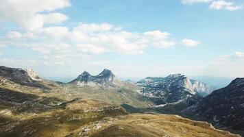 parte superior ver de montaña panorama en contra azul cielo. existencias. rocoso picos de montañas con cubrir de césped a estribaciones crear hermosa paisaje video