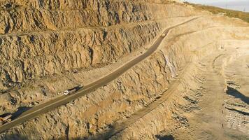 Top view of quarry with trucks. Shot. Multistage pit wall for mining and passing on her road for trucks and dumpers. Stepwise technology of extraction of stone video