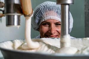 causa mujer trabajando en un comida fábrica vistiendo protector ropa y guantes. foto