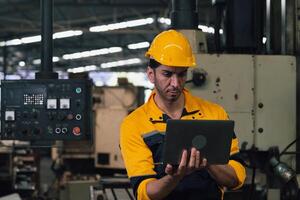 Caucasian engineer using a laptop in a factory. man working in factory. photo