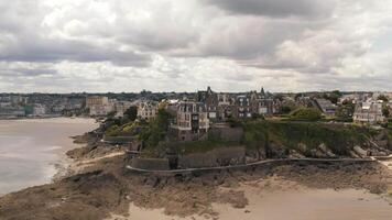 hermosa aéreo ver de gris antiguo europeo ciudad cerca el arena orilla en verano en contra gris nublado cielo. acción. maravilloso europeo arquitectura video