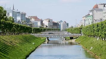 bellissimo Visualizza di città con verde alberi e bianca case lungo il fiume. azione filmato. romantico case lungo il fiume canale nel il vecchio città di mezzo Europa. video