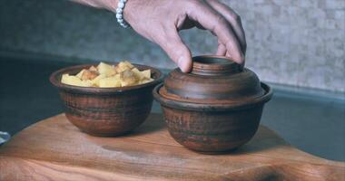 Baking chopped potatoes in the oven. Spices, clay pots. Cinematic video