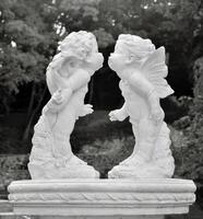 Two statues of cherubs kissing in a fountain photo