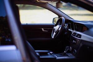 Inside a modern car view, city car interior background. Shift lever, car steering wheel and sensors. photo