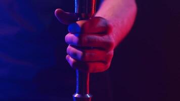 Close up of hookah metal parts in the dark room under the red and blue lights. Action. Concept of traditional Turkish relaxation, man hand tightening the metal tube of shisha. video